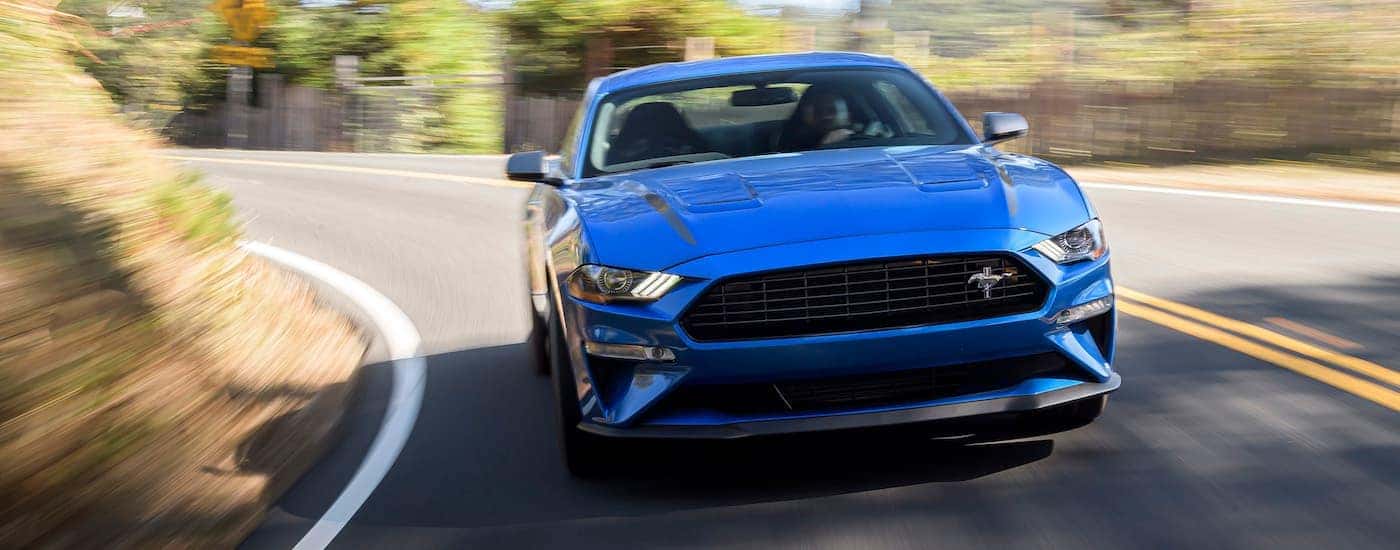 A grey/blue 2020 Ford Mustang High Performance is shown from the front rounding a corner.