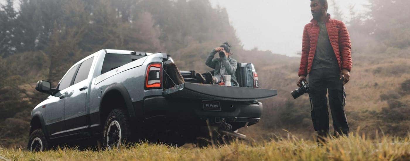 A light blue 2022 Ram 2500 Power Wagon is shown in a field with photographers.