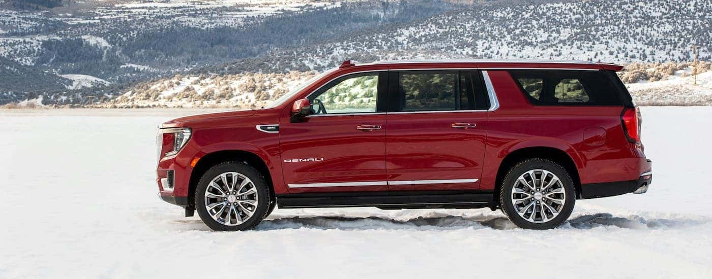 A red 2022 GMC Yukon XL Denali is shown parked on snow.