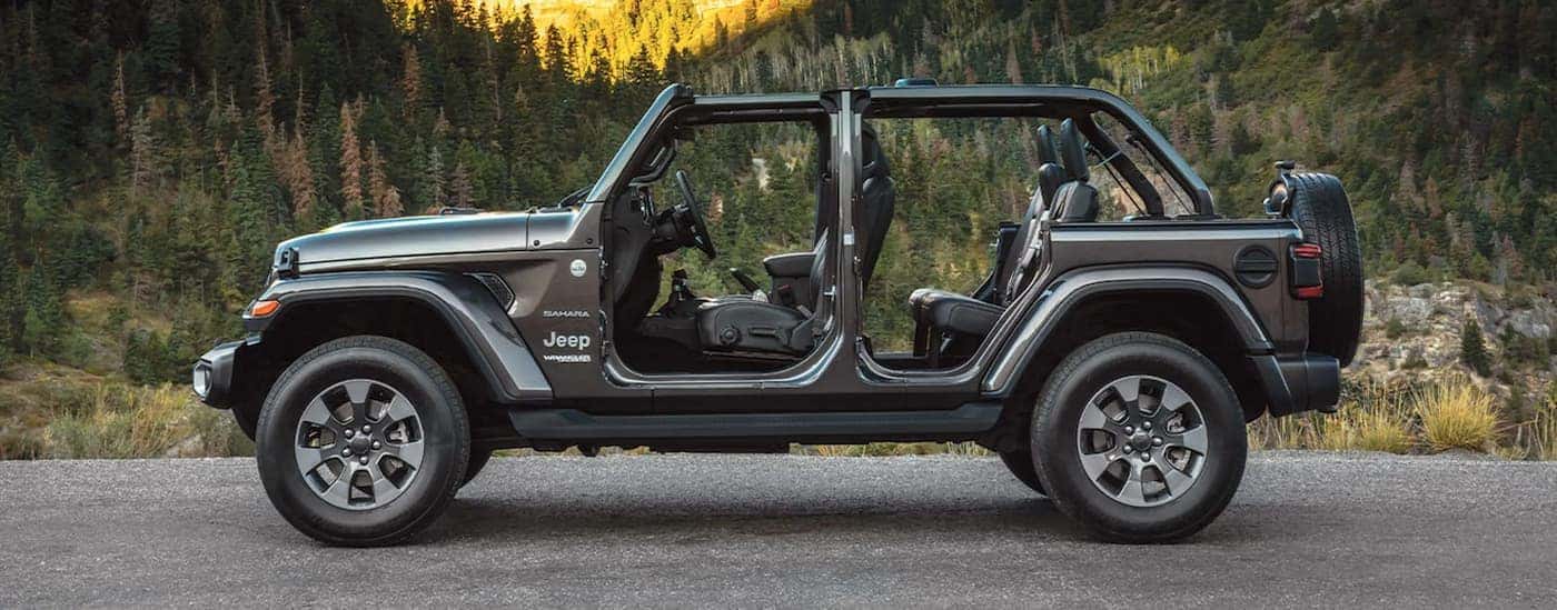 A gray 2022 Jeep Wrangler Sahara is shown from the side with the doors off.
