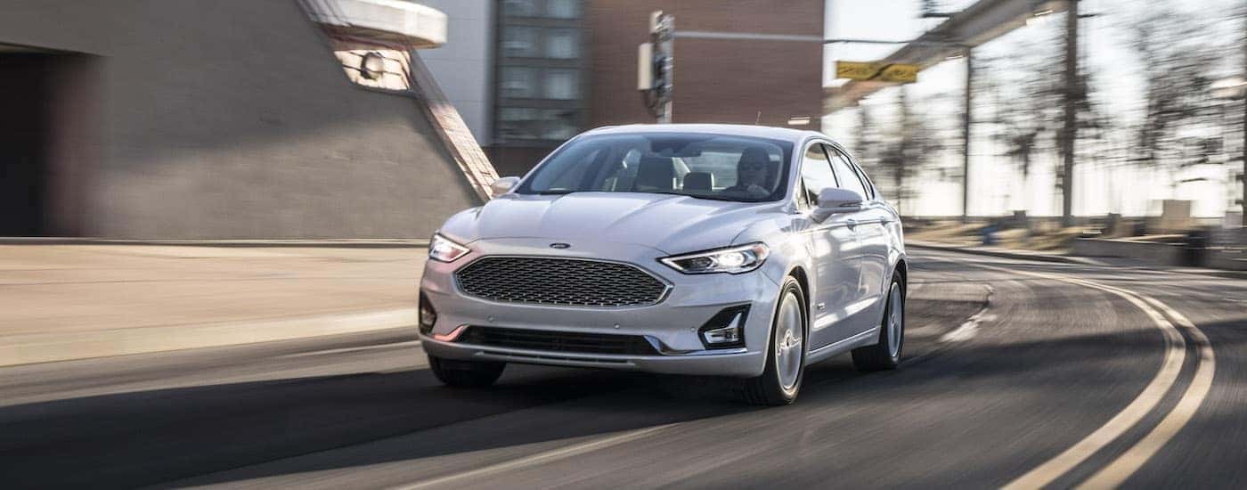 A white 2020 Ford Fusion is shown from the front while rounding a corner.