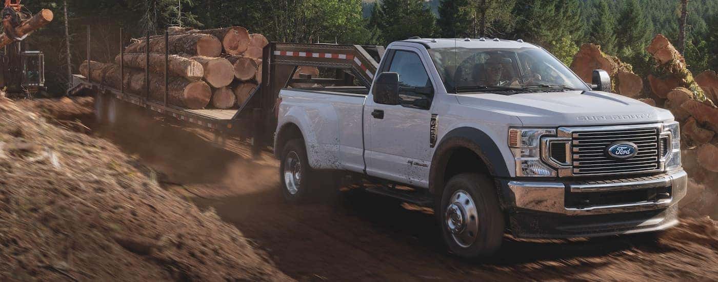 A white 2021 Ford F-450 Super Duty is shown towing hay bales.