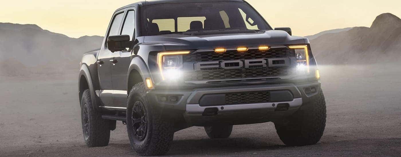 A black 2022 Ford F-150 Raptor is shown parked in a desert.