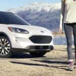 A couple is shown walking away from a white 2022 Ford Escape Titanium.
