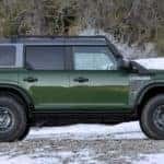 A dark green 2022 Ford Bronco Everglades is shown from the side parked on a snowy trail.