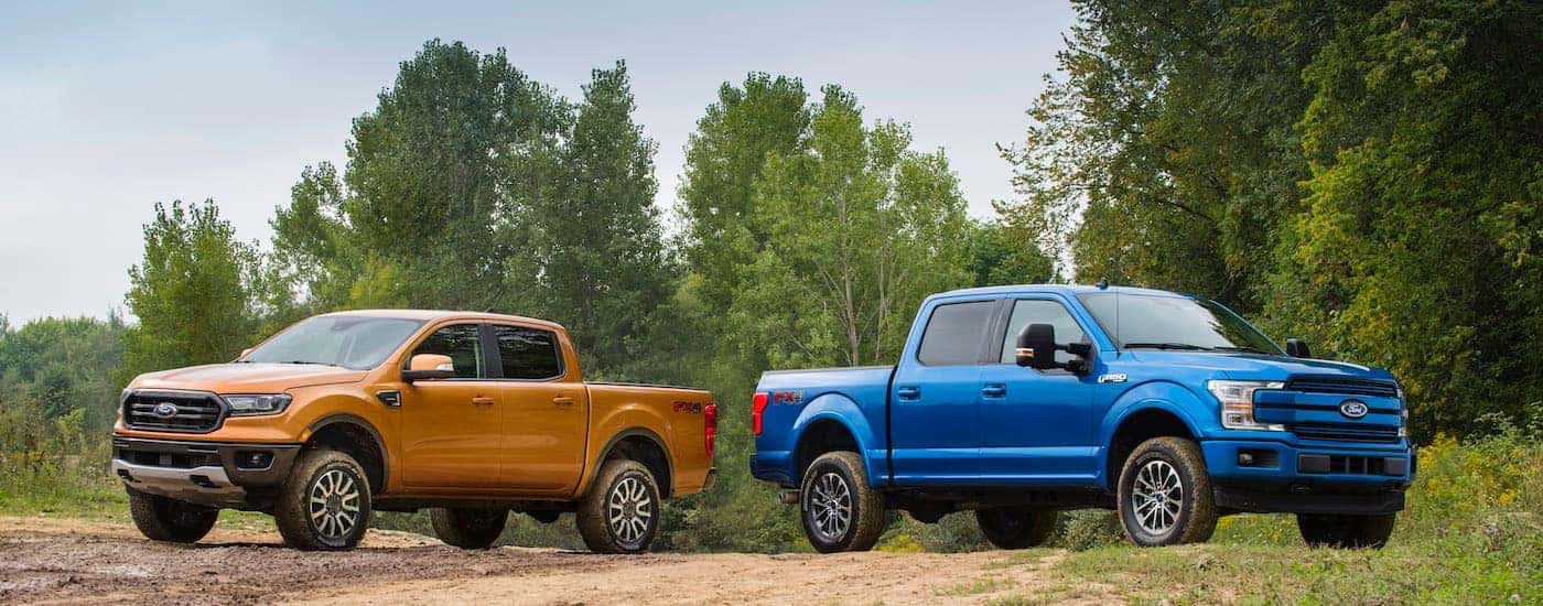 A gold 2019 Ford Ranger is shown facing away from a blue 2019 Ford F-150 while parked off-road.