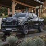 A black 2024 GMC Sierra Denali Ultimate is shown from the front at an angle.