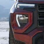 A red 2023 GMC Canyon AT4x is shown from the front in close-up.