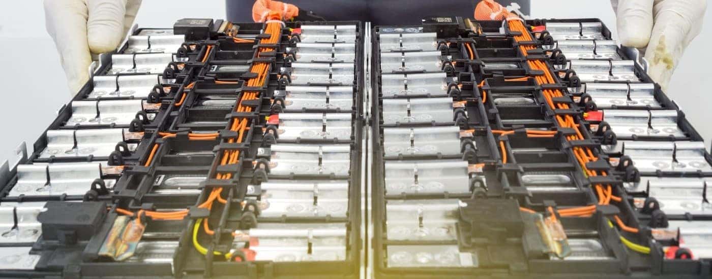 A tech is shown near an EV battery after asking 'How do electric vehicles work?'