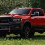 A red 2024 Ram 2500 Power Wagon is shown from the front at an angle after leaving a dealer that has a Ram 2500 for sale.