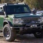 A green 2024 Ford Bronco Everglades is shown parked off-road after visiting a Gunnison Ford dealer.