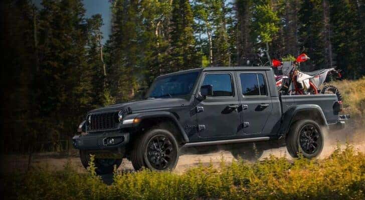A gray 2024 Jeep Gladiator Nighthawk is shown parked off-road after viewing trucks for sale near Buena Vista.