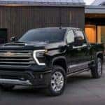 A black 2024 Chevy Silverado 2500 HD High Country is shown parked on a driveway.