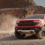 A red 2024 Ford Ranger Raptor off-roading in a desert.