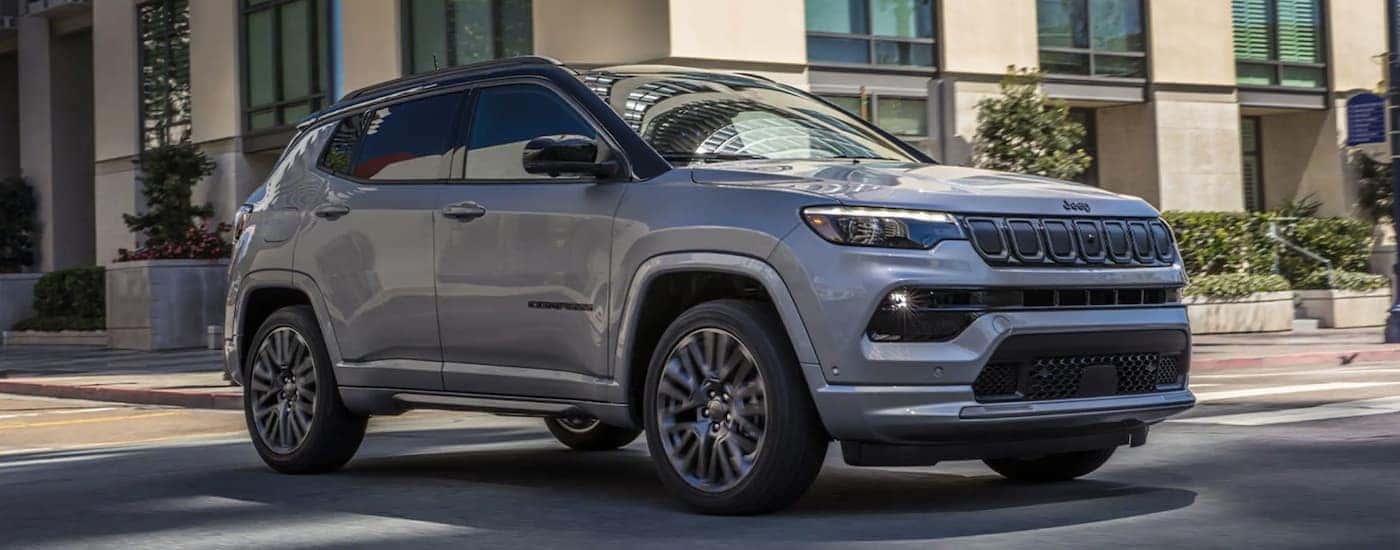 A grey 2022 Jeep Compass driving to a Jeep dealer.