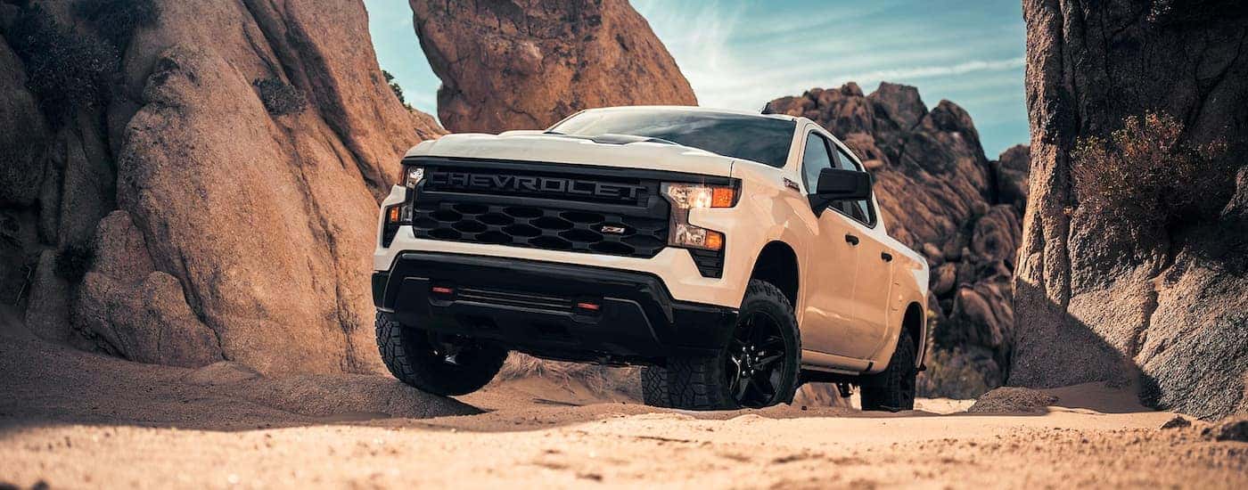 A white 2024 Chevy Silverado 1500 Z71 driving up a sand dune.