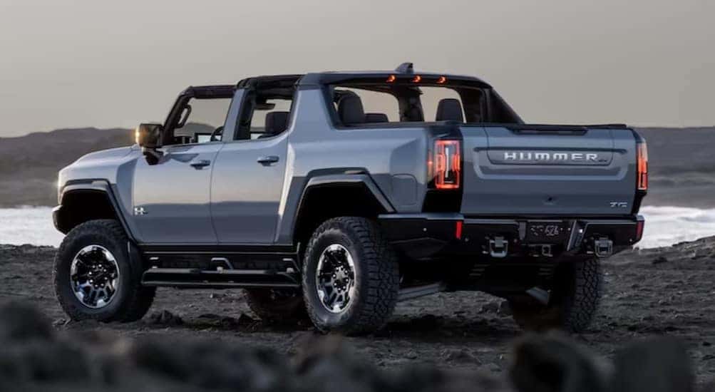 A blue 2025 GMC Hummer EV Pickup is shown parked off-road after visiting a GMC dealer.