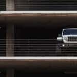 A silver 2025 Jeep Wrangler 4xe parked in a parking garage.