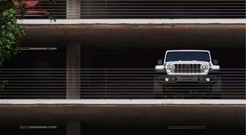 A silver 2025 Jeep Wrangler 4xe parked in a parking garage.