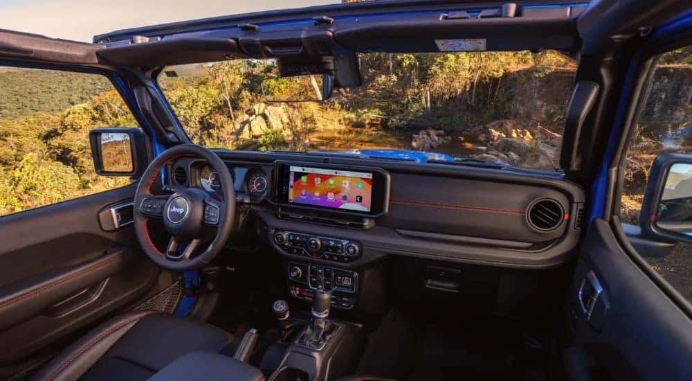 Interior and dash in a blue 2025 Jeep Wrangler Unlimited Rubicon.