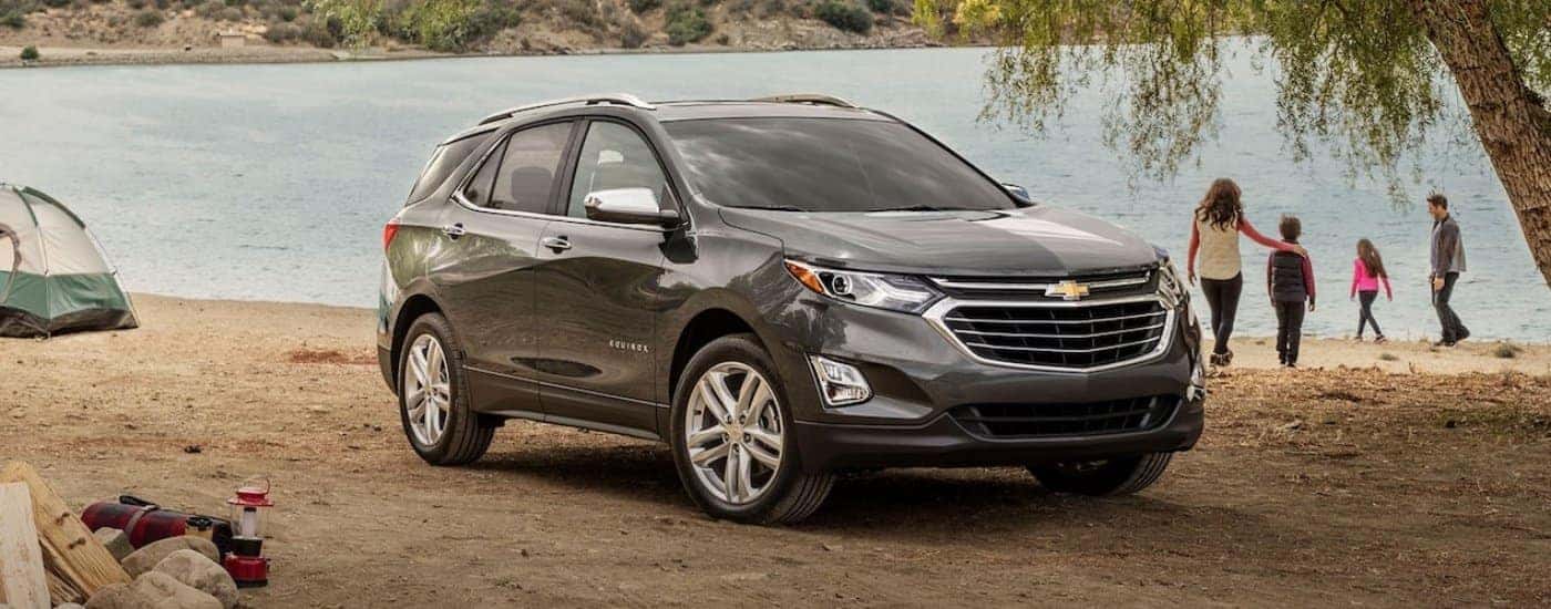 A grey 2018 Chevy Equinox for sale parked near a lake.