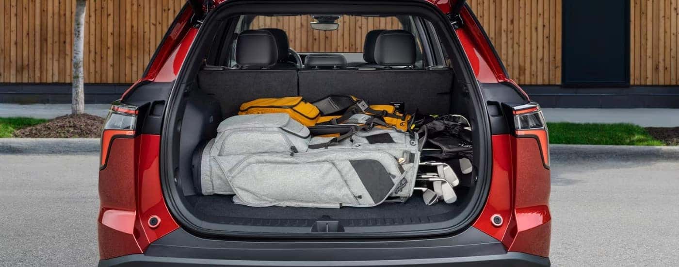 Gold clubs in the trunk of a red 2025 Chevy Equinox.