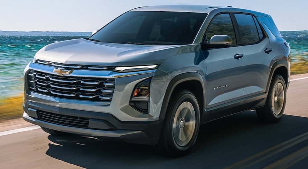 Silver 2026 Chevy Equinox driving down an open road.