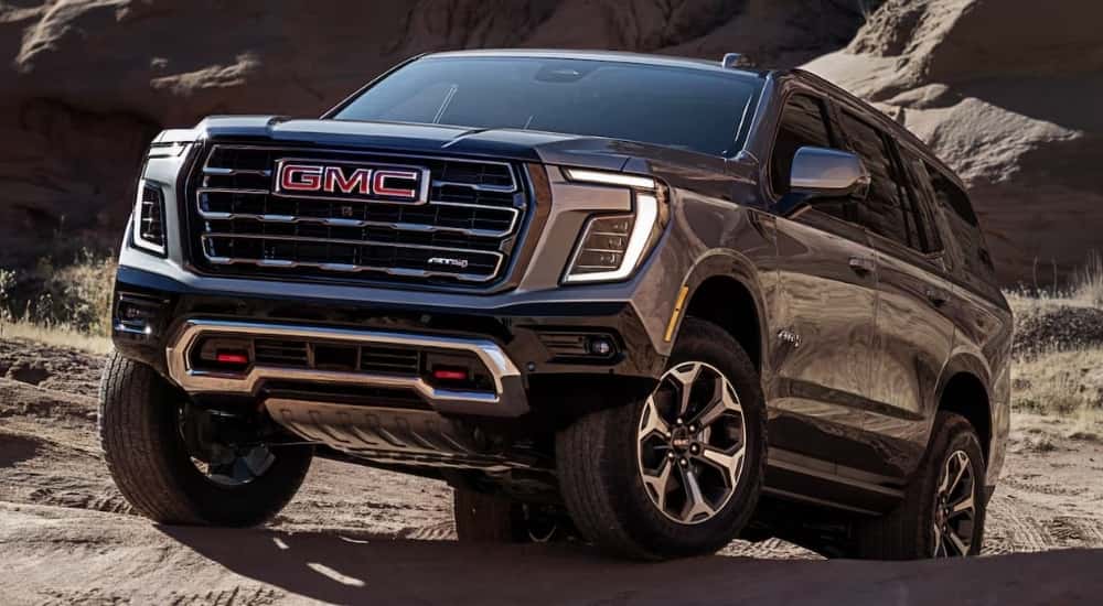 A dark gray 2025 GMC Yukon AT4 off-roading