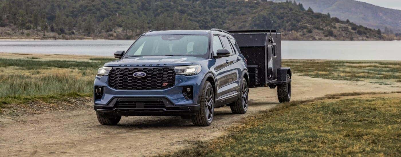 A blue 2025 Ford Explorer ST towing a trailer.