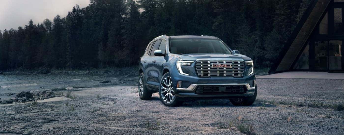 A blue 2025 GMC Acadia Denali is shown from the front at an angle.