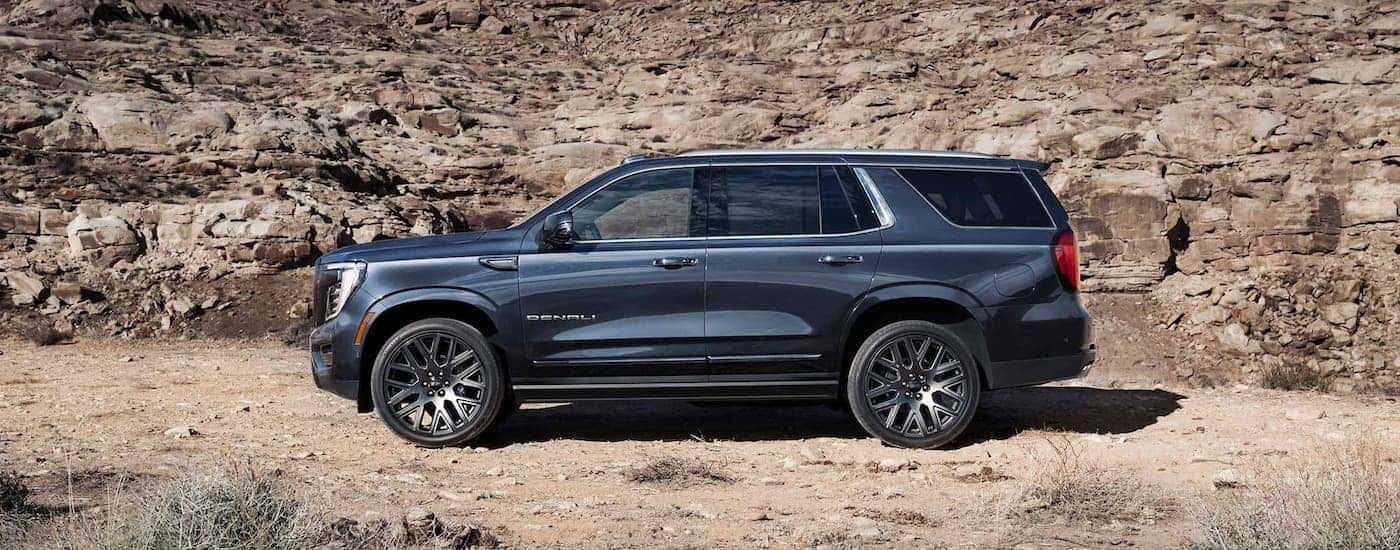 Black 2026 GMC Yukon Denali parked off-road.
