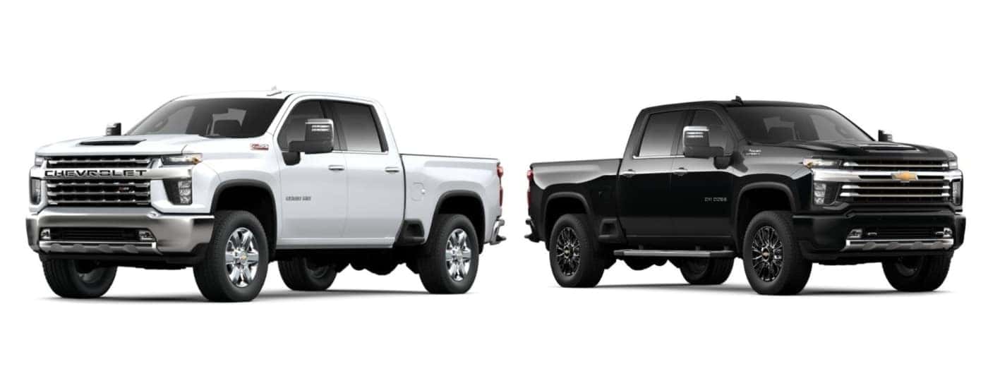 White 2022 Chevy Silverado 2500 HD Z71 angled left and black 2022 Chevy Silverado 3500 HD High Country angled right