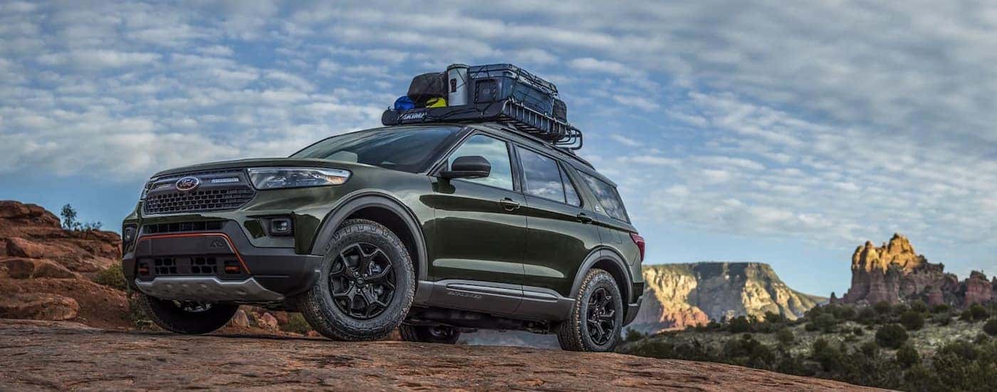 A green 2022 Ford Explorer is shown from the side parked in the mountains.