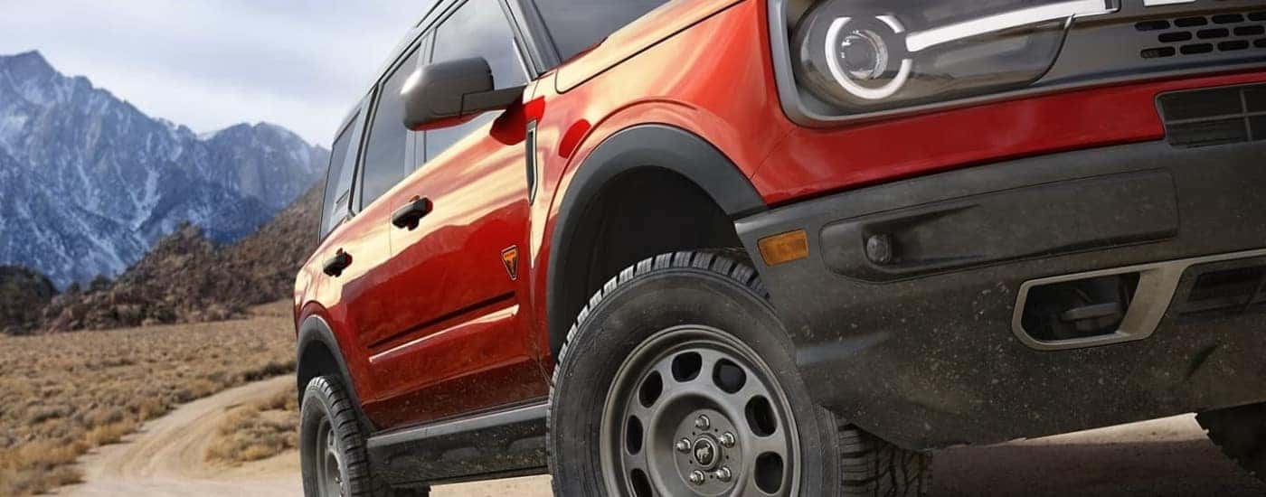 A red 2023 Ford Bronco Sport is shown off-roading.
