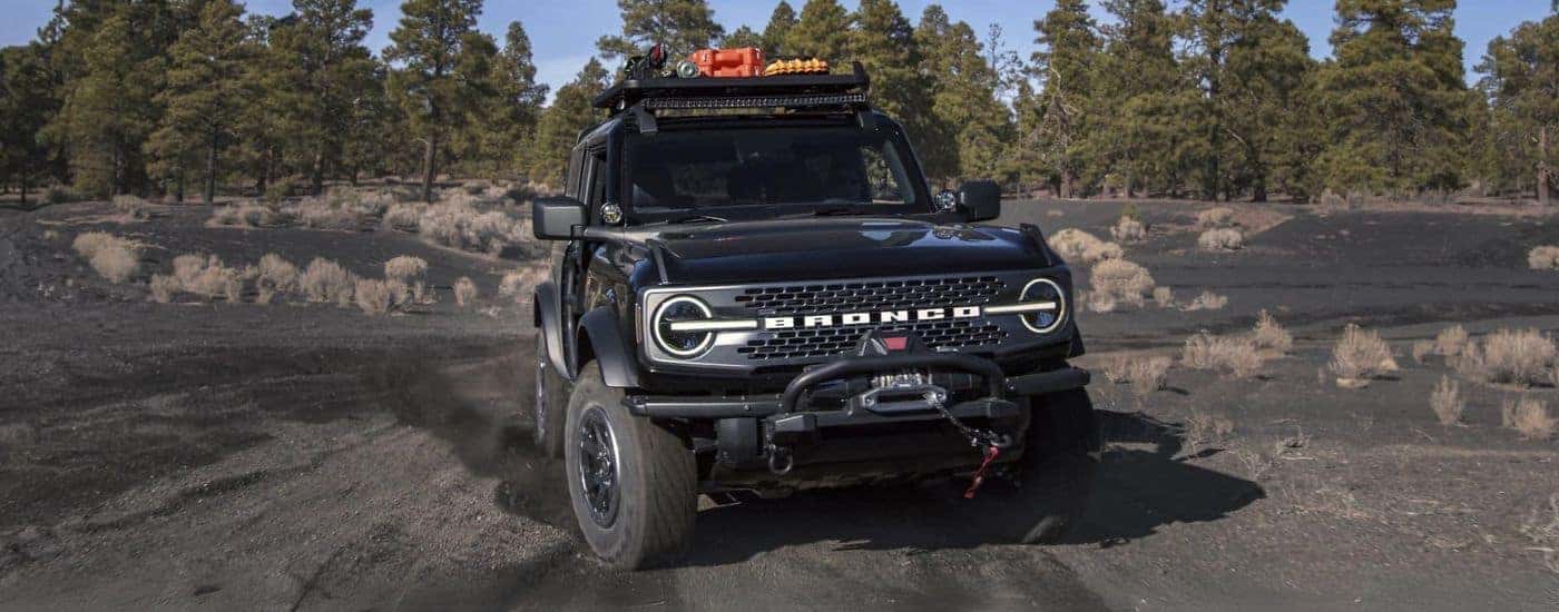 A black 2022 Ford Bronco WildTrak is shown off-roading after leaving a Crested Butte Ford dealer.