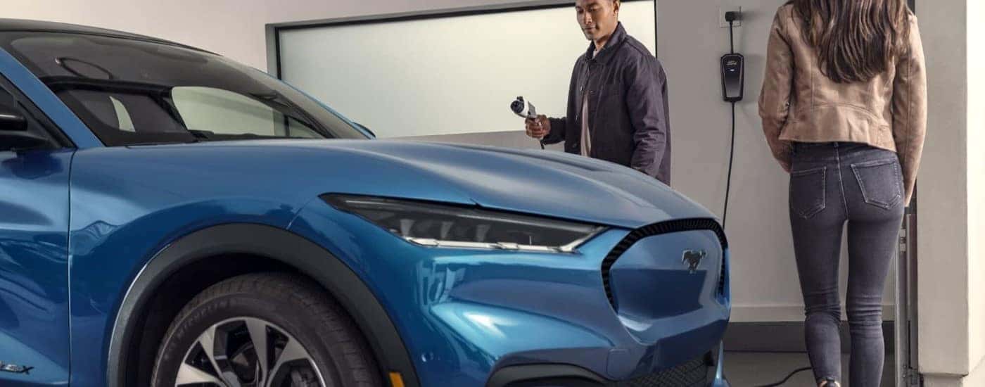 A blue 2023 Ford Mustang Mach-E is shown in a garage.