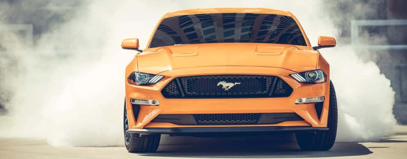 Orange 2018 Ford Mustang doing a burnout
