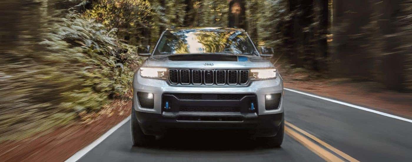 A silver 2022 Jeep Grand Cherokee 4xe is shown from the front after leaving a Jeep dealer near Fairplay, CO.