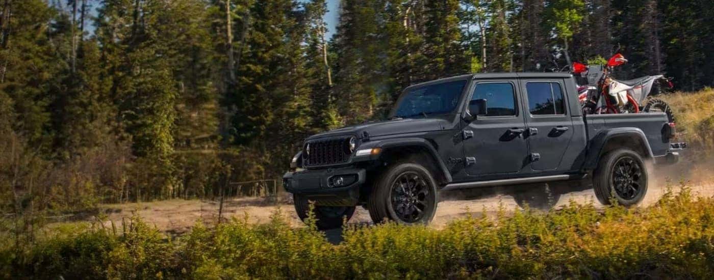 A gray 2024 Jeep Gladiator Nighthawk is shown parked off-road after viewing trucks for sale near Buena Vista.