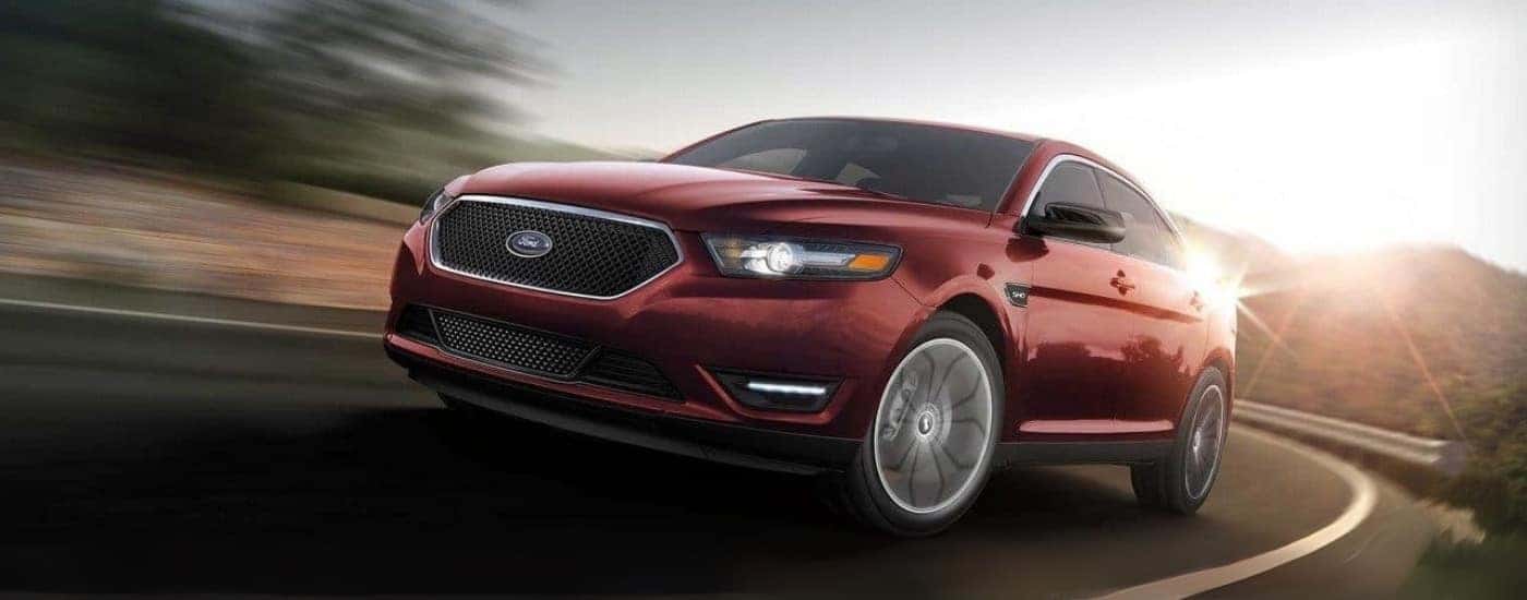 A red 2018 Ford Taurus SHO driving to look at used cars for sale