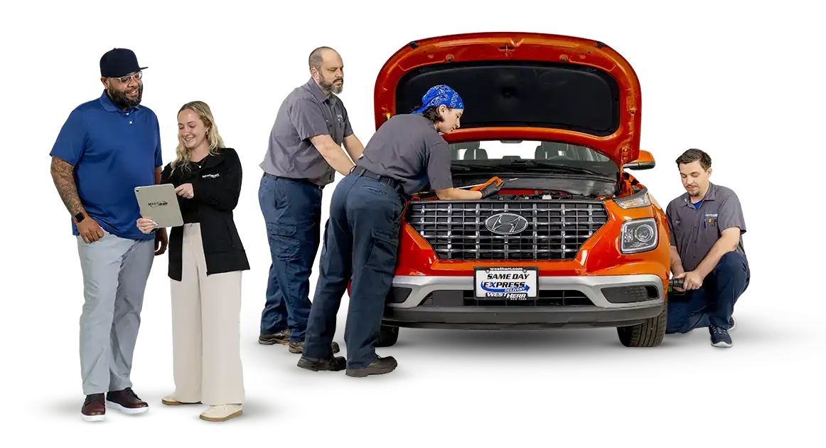 Saleswoman and customer standing in front of service team working on car engine